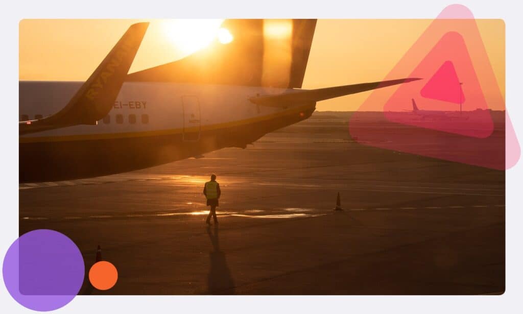A lone airfield employee standing near a plane on an airfield