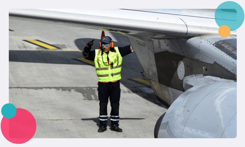 A airfield traffic controller guiding an aircraft 