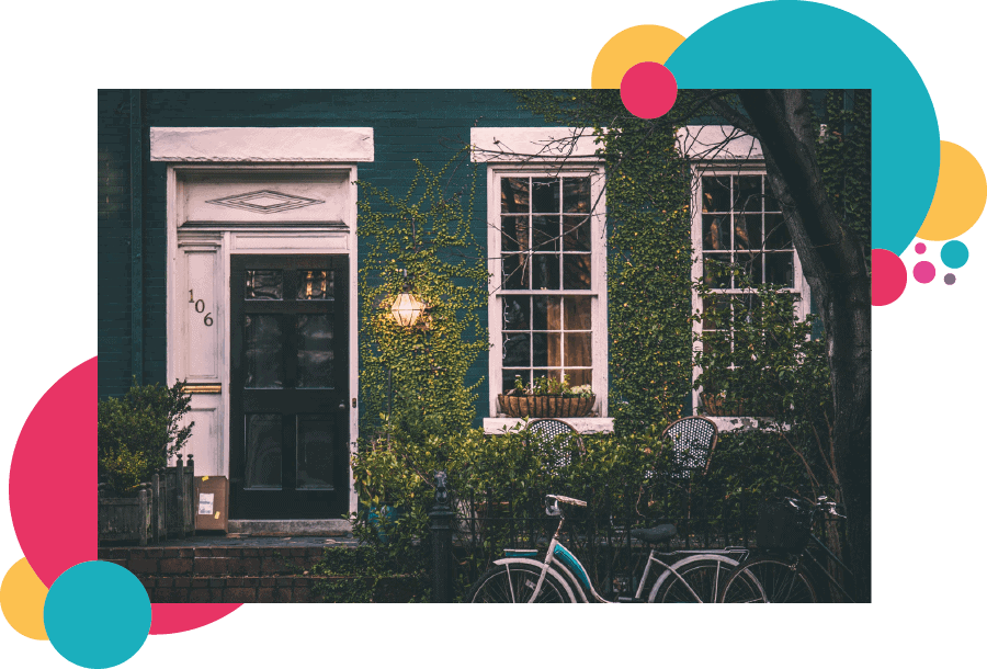 A green house viewed from the front with a bicycle outside