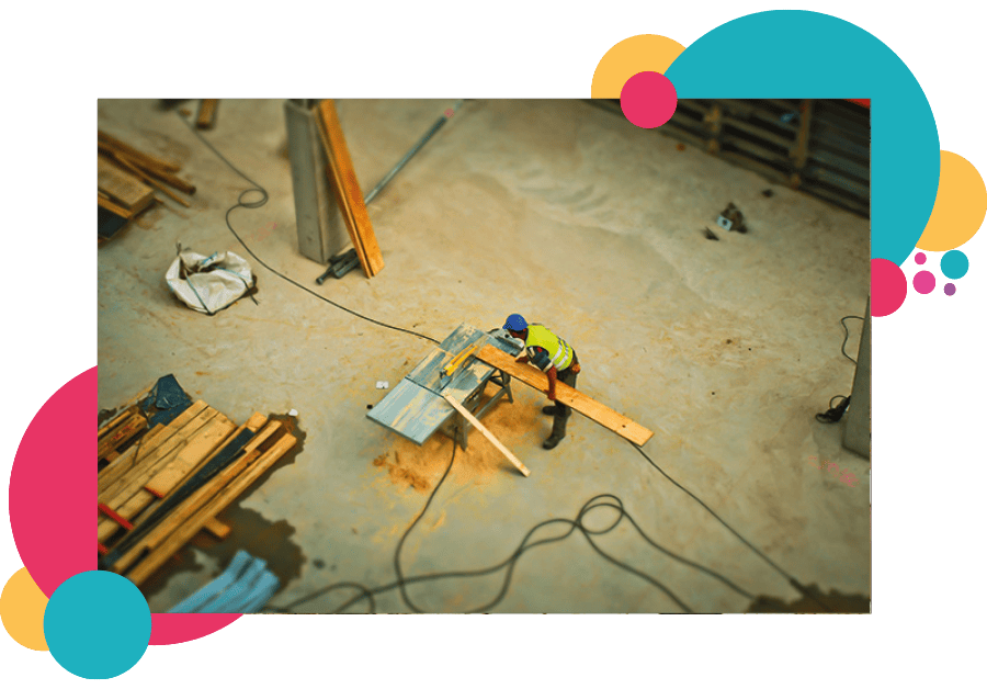 A lone working construction worker cutting wood on a construction site