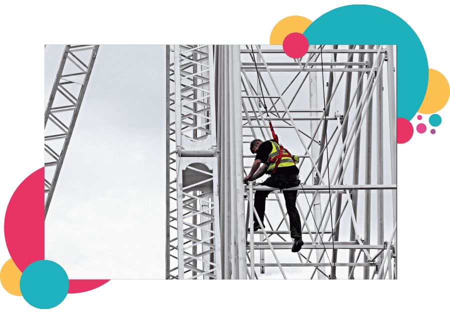 A lone worker working at height strapped into a harness to prevent the risks of falling