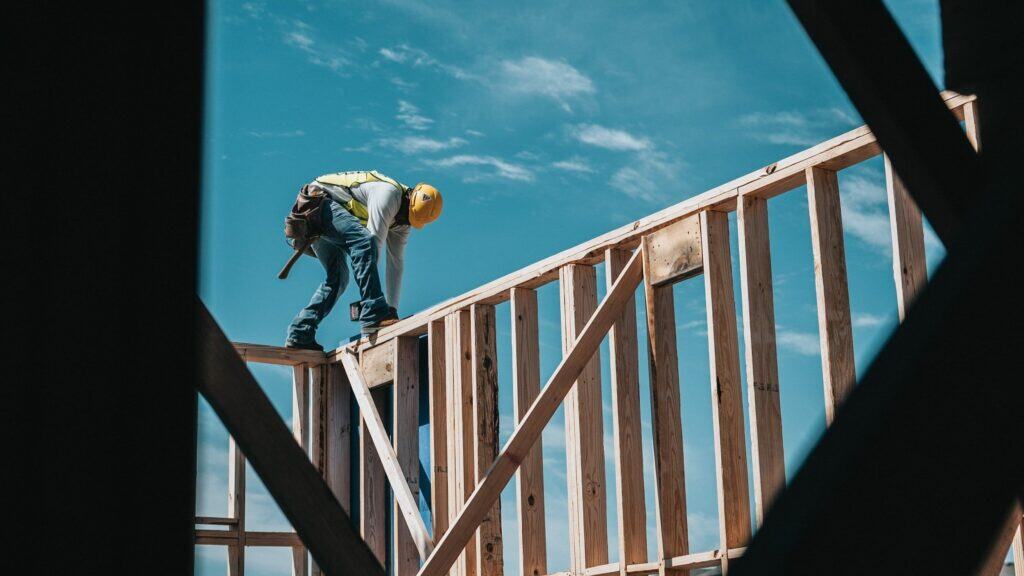 A construction worker building the frame of a new property