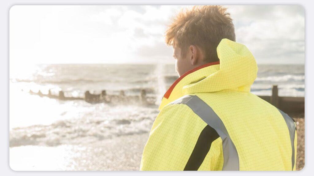 A engineer wearing hi-vis on the coast with no employees nearby