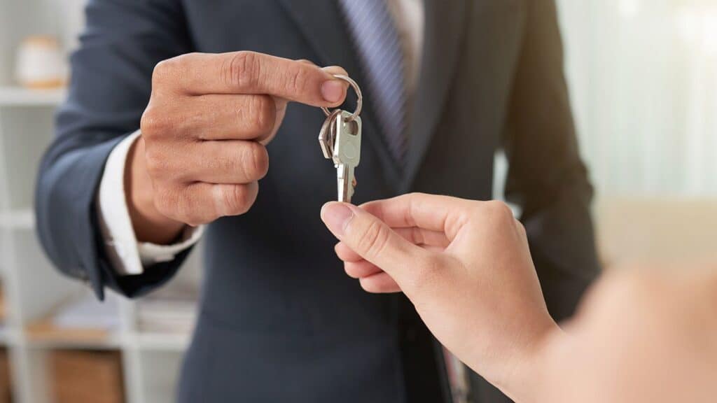 An estate agent handing a client a set of keys