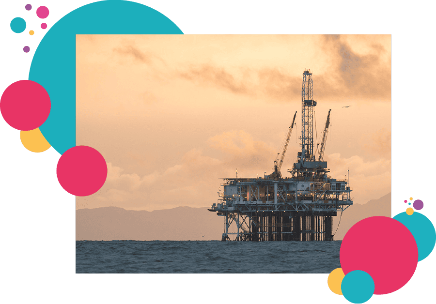 An oil rig on the ocean with mountains in the background