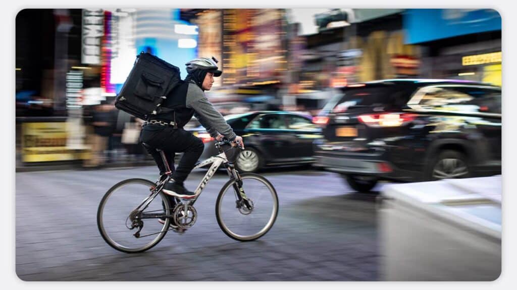 A cyclist travelling down a busy city road