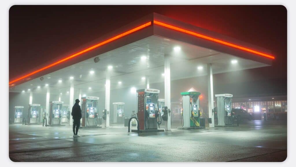 A foggy garage forecourt at night with a single lone person in view