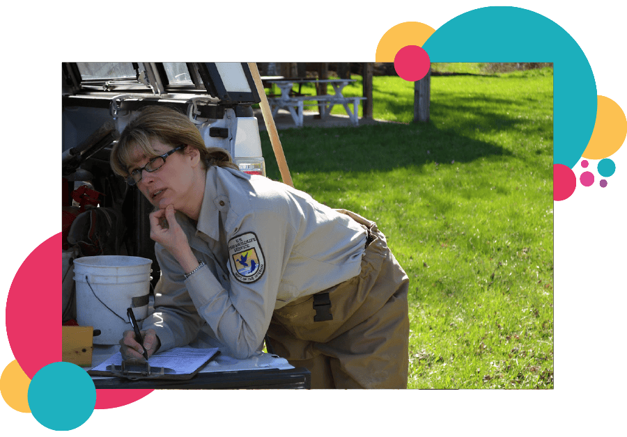 A lone working park ranger writing notes on the back of her truck