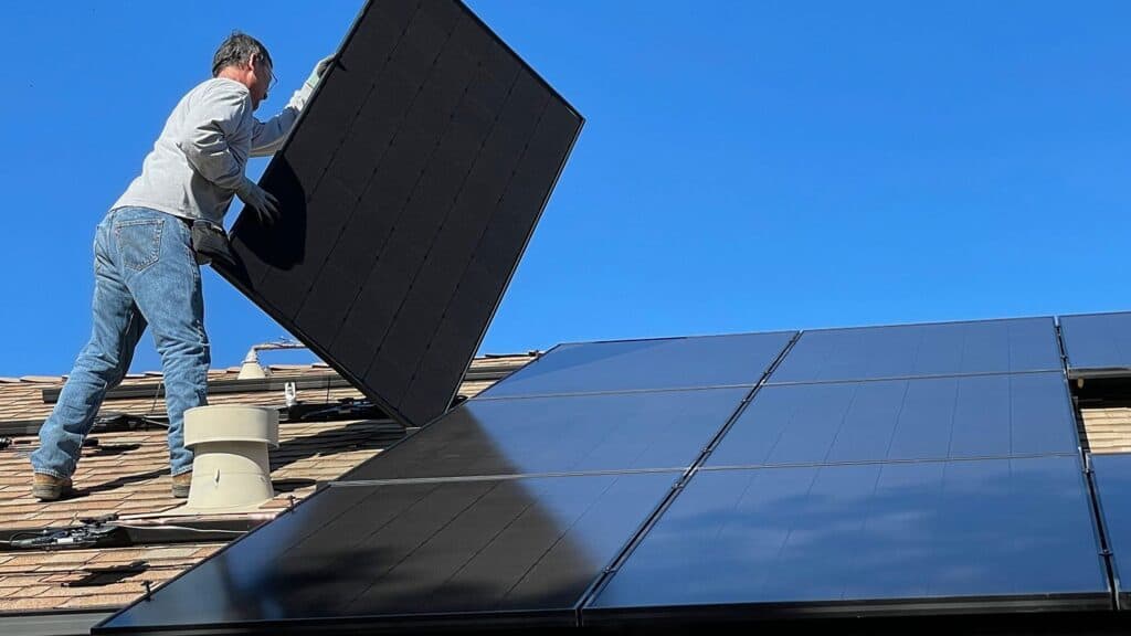 An engineer installing solar panels on a roof