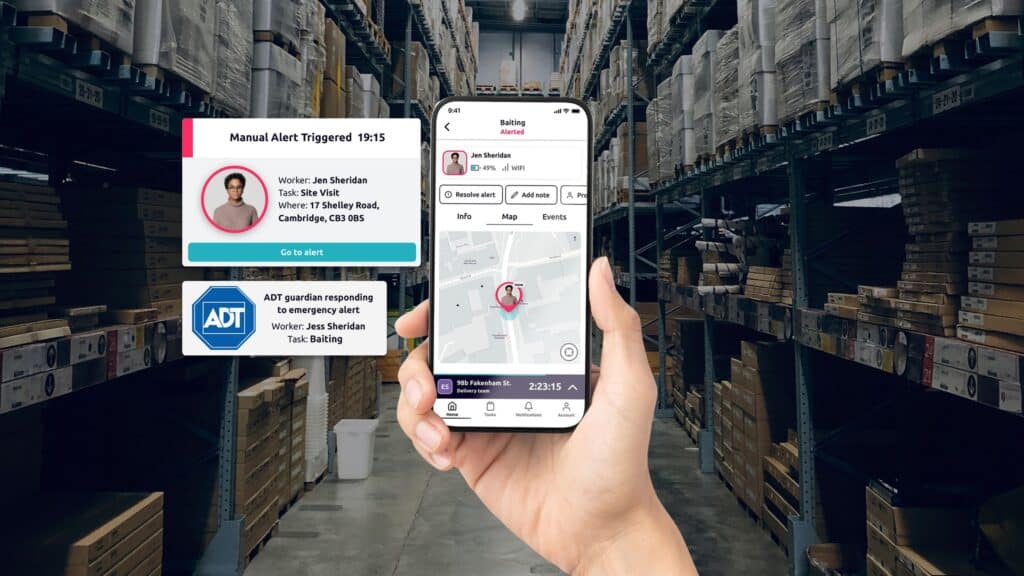 A warehouse employee holding up the Safepoint app on a phone