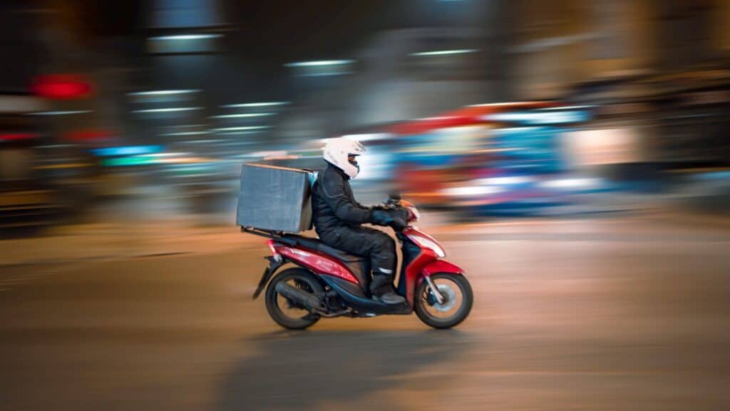 A delivery driver on a motorcycle