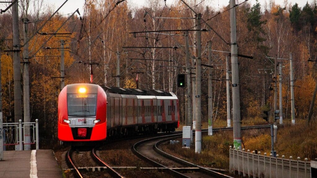 A train turning a corner as viewed from a station platform