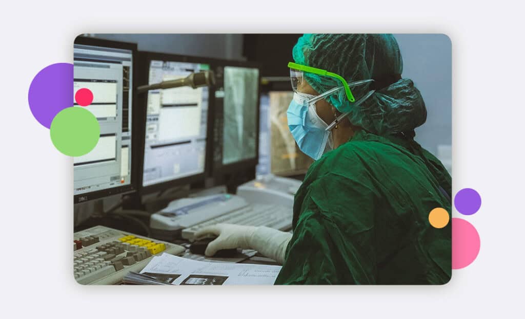 A doctor in full PPE working alone at a PC
