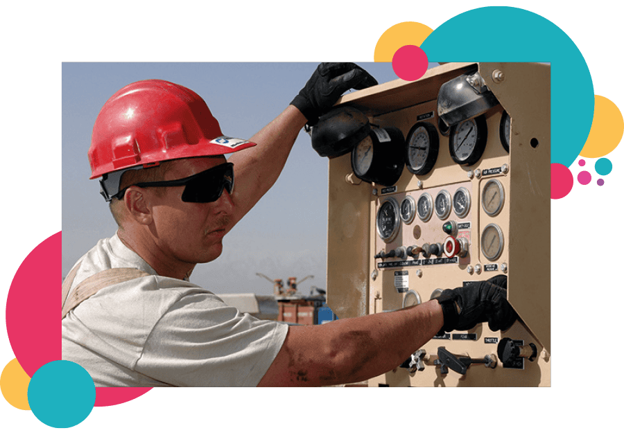 A lone worker in the oil and gas sector pressing buttons on a large electronic panel